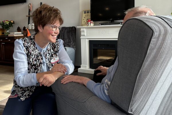 In gesprek met cliënt in de huiskamer